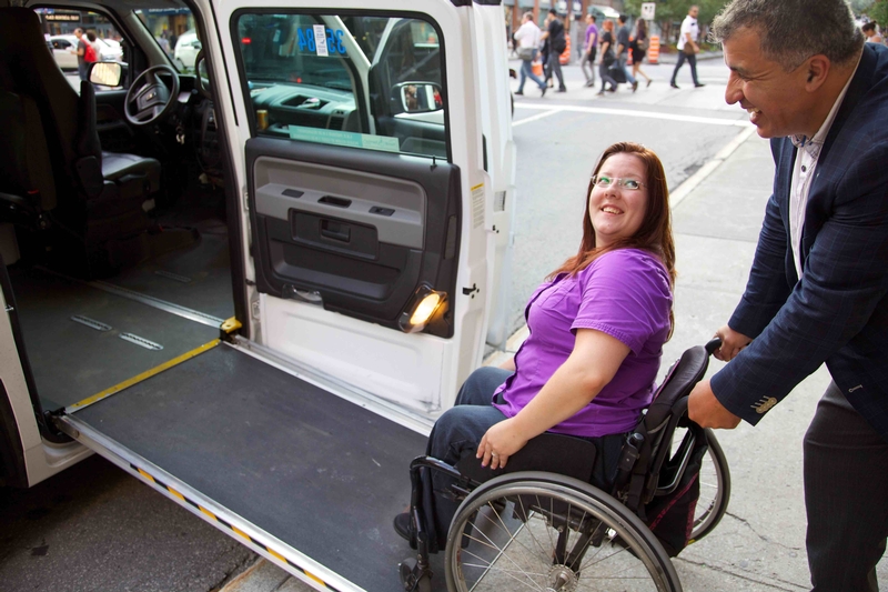 Femme en fauteuil roulant entrant dans un taxi