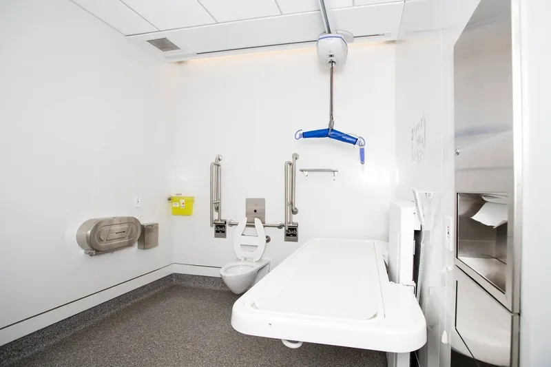 Salle de bain avec table de soins et toilette adaptée