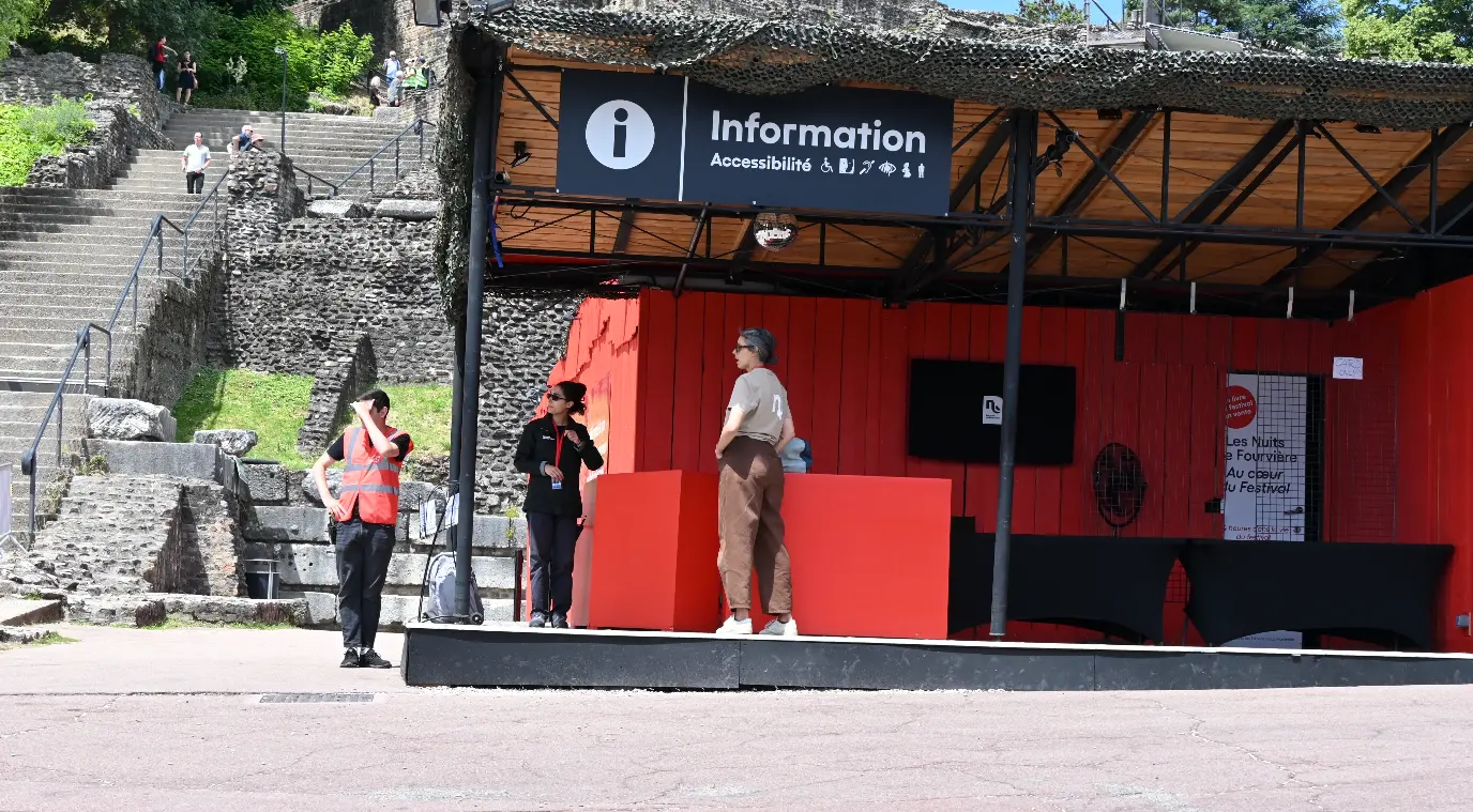 Kiosque d’information extérieur avec une grande enseigne « Information – Accessibilité » et plusieurs pictogrammes liés aux services accessibles.