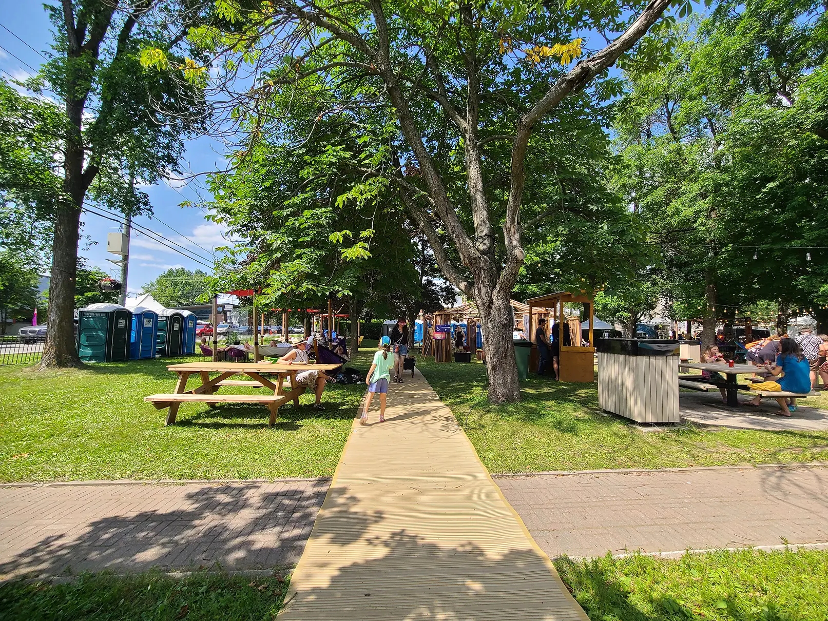Cheminement temporaire rigide aménagé sur le gazon entre les différentes zones d’un festival.