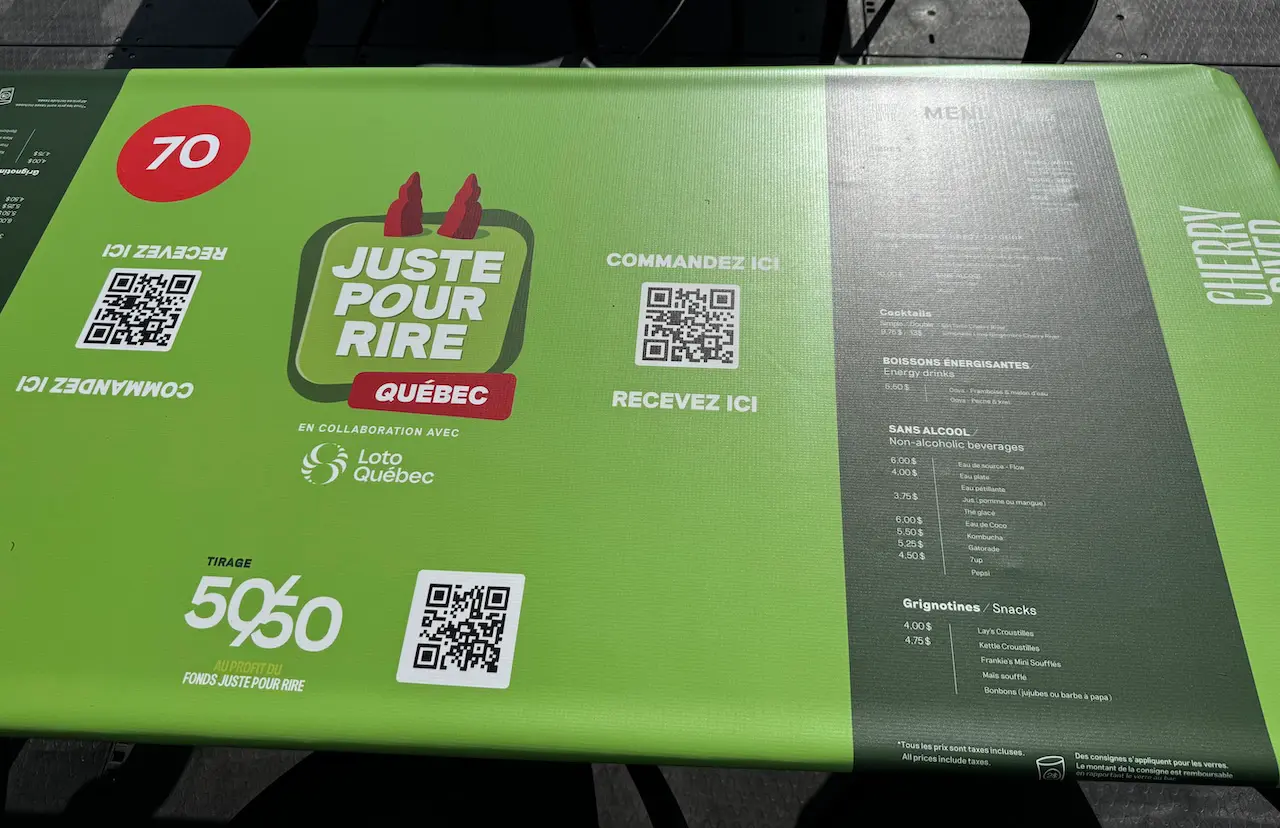 Comptoir vert avec un menu et des codes QR permettant de commander et de recevoir des boissons.