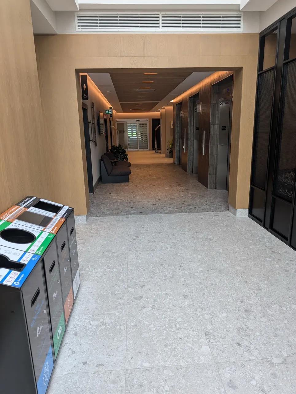 Couloir menant de la réception aux ascenseurs et salle de toilette publique